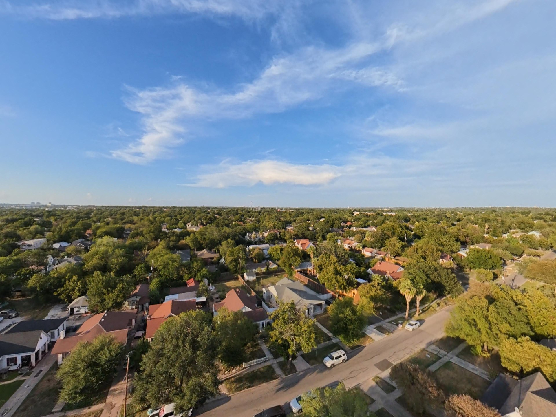 Oblique aerial view of the surrounding homes, streets and tree canopy